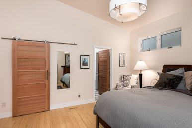A large mid-century modern master light wood floor and brown floor bedroom idea in Portland with white walls.